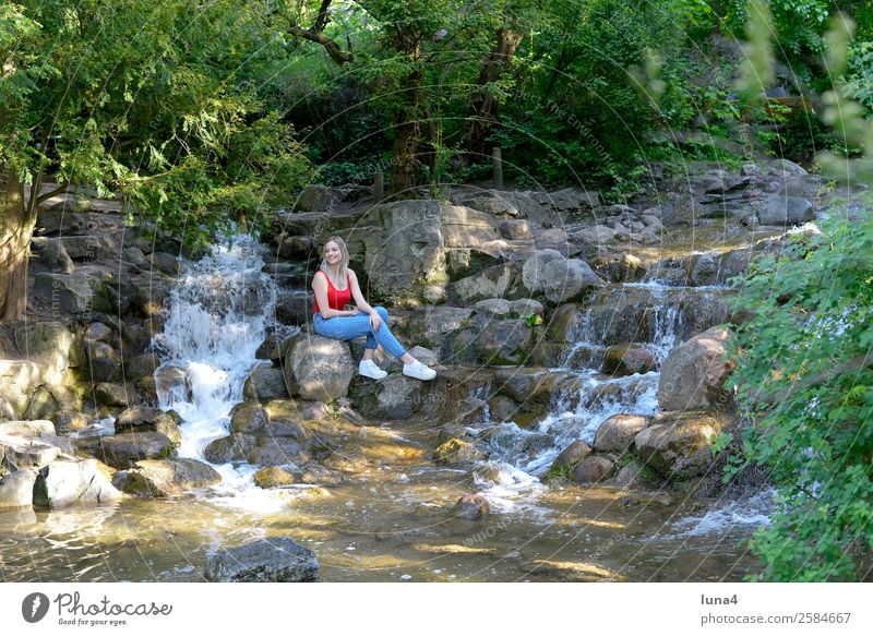 Frau sitzt am Wasserfall Lifestyle Freude Glück schön Zufriedenheit Erholung Freizeit & Hobby Tourismus Sommer Junge Frau Jugendliche Erwachsene Park Stadt