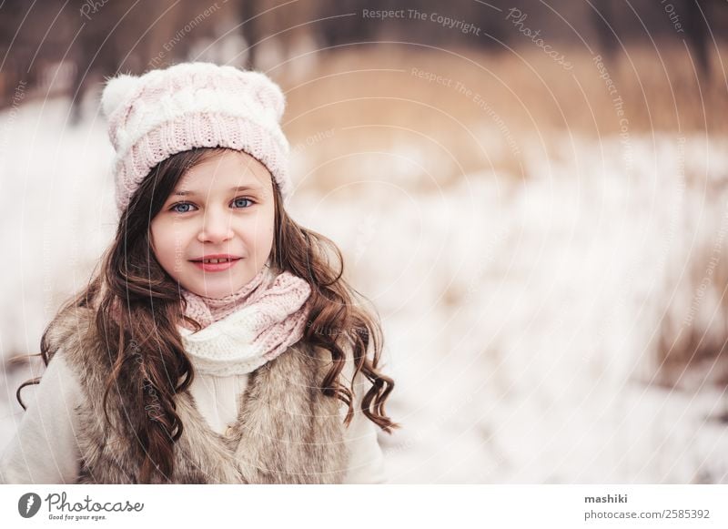 Winterportrait eines glücklichen Kindes Mädchens beim Spazierengehen Freude schön Freizeit & Hobby stricken Schnee Kindheit Wetter Baum Wald Mode Mantel