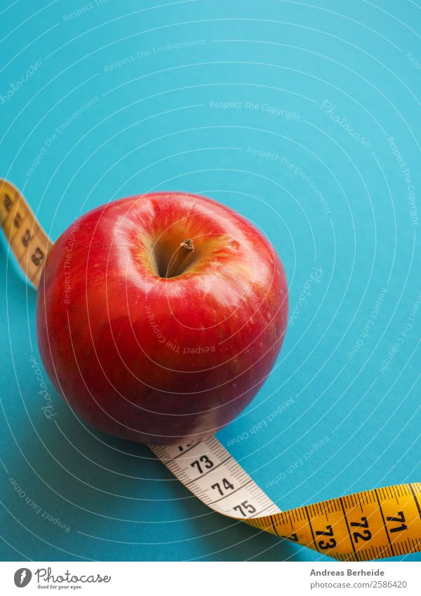 Roter Apfel mit einem Maßband Frucht Bioprodukte Vegetarische Ernährung Diät Fasten Lifestyle Gesunde Ernährung Übergewicht Leben Wohlgefühl