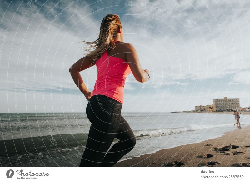 Frau in Sportkleidung läuft an der Meeresküste Lifestyle Freude sportlich Fitness Wellness Leben Strand Sport-Training Joggen Mensch feminin Junge Frau