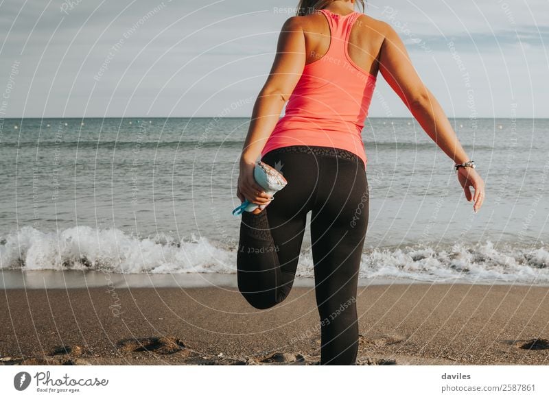 Bein, das sich vor dem Meer streckt. Sportlerin. Lifestyle Körper sportlich Fitness Wellness Leben Freizeit & Hobby Strand Sport-Training Joggen Mensch feminin