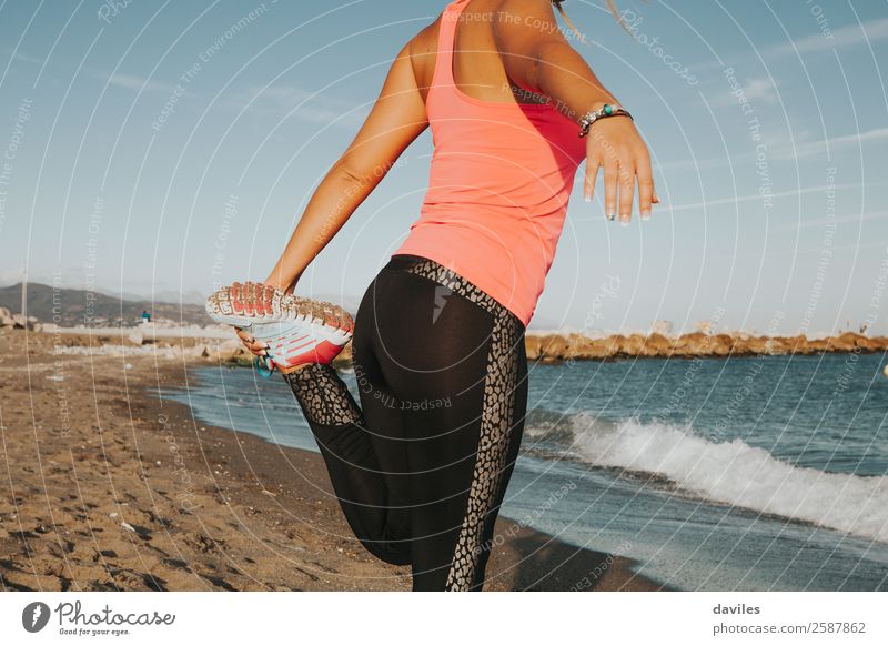 Körper eines Mädchens beim Strecken der Beine am Meeresufer. Lifestyle Leben Sommer Strand Sport Fitness Sport-Training Joggen Mensch feminin Junge Frau