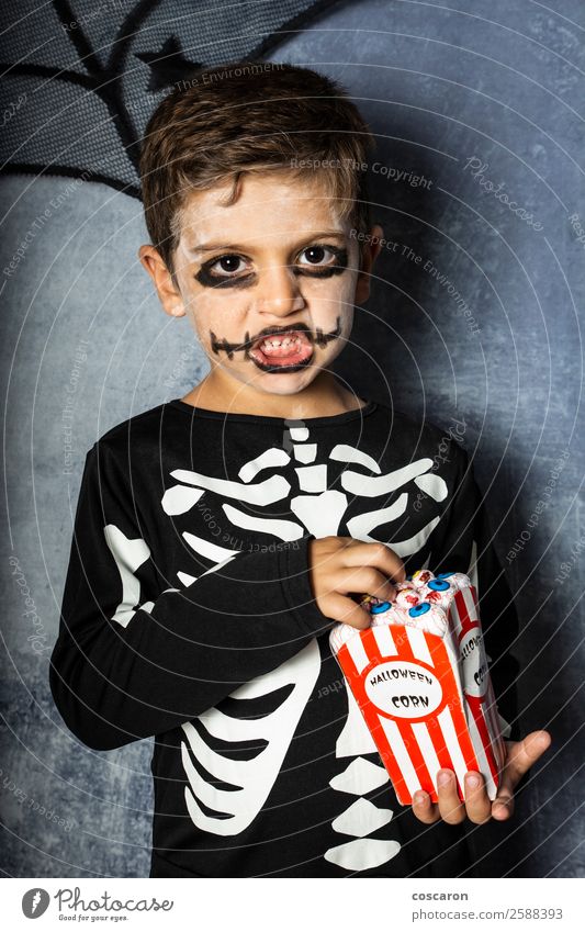 Kleines Kind in einem Skelettkostüm isst an Halloween gefälschte Augen. Freude Glück Gesicht Schminke Feste & Feiern Karneval Jahrmarkt Mensch Kleinkind Junge