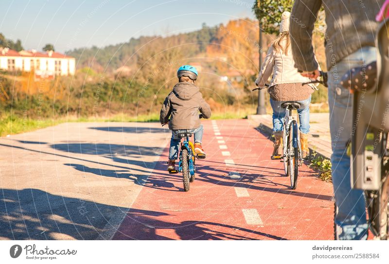 Rückansicht einer glücklichen Familie mit Kindern auf Fahrrädern Lifestyle Glück Erholung Freizeit & Hobby Sonne Winter Sport Baby Junge Frau Erwachsene Mann