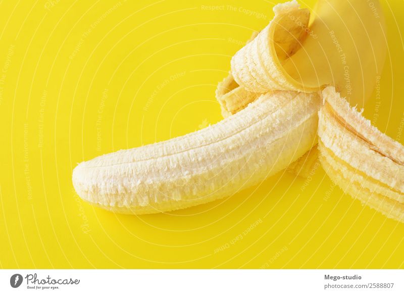 Draufsicht. Geschälte Banane auf gelbem Hintergrund. Gesundheitskonzept Frucht Ernährung Essen Frühstück Vegetarische Ernährung Diät exotisch Haut Natur frisch