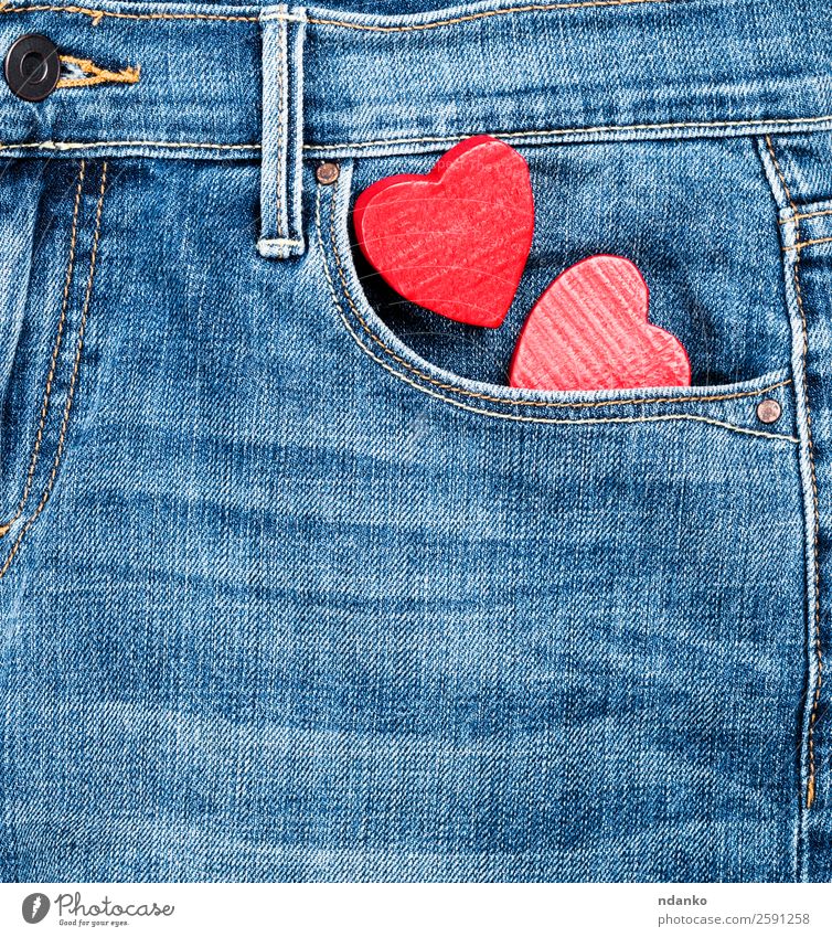 Jeans und zwei rote Holzherzen Stil Valentinstag Mode Bekleidung Hose Jeanshose Stoff Herz Liebe blau Farbe Tradition Hintergrund Leinwand lässig Baumwolle
