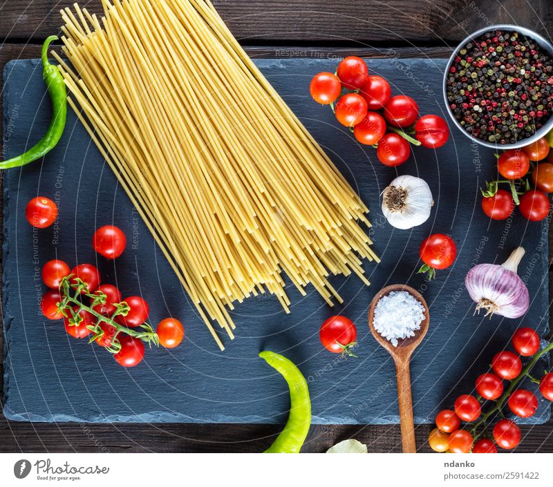 Nudelspaghetti auf schwarzem Hintergrund Gemüse Teigwaren Backwaren Kräuter & Gewürze Vegetarische Ernährung Löffel Tisch Küche Holz Linie Essen frisch groß