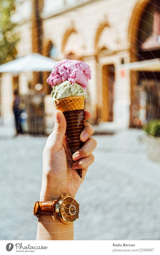 Frau hält grüne und rosa Eiscreme in der Hand. Lebensmittel Milcherzeugnisse Dessert Speiseeis Süßwaren Ernährung Essen Fastfood Lifestyle Reichtum Stil