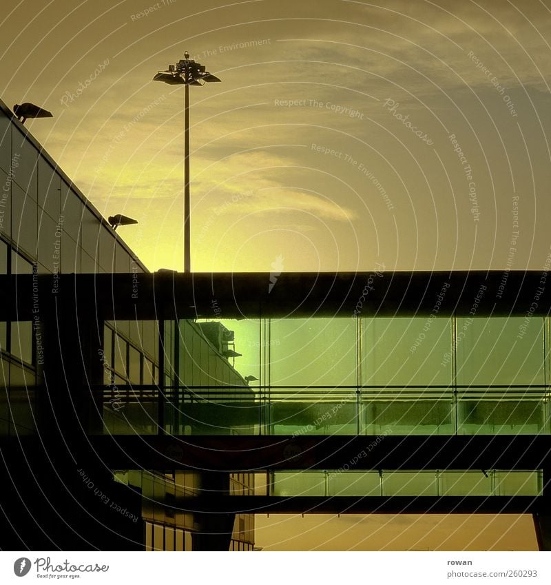bruecke Bauwerk Gebäude Architektur Fassade Fenster ästhetisch modern kalt Glas Glasfassade grün Lampenständer Flughafen Sonnenuntergang Brücke Abend