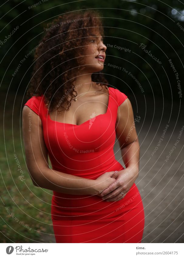 Frau im roten Kleid feminin Erwachsene 1 Mensch Park Wiese Wald Haare & Frisuren brünett langhaarig Locken beobachten festhalten Blick stehen elegant