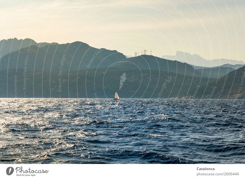 Windkraft; das Meer, ein Segelboot, bergige Küste, Windräder auf der Bergkuppe Ferien & Urlaub & Reisen Sommer Sommerurlaub Wellen Segeln Erneuerbare Energie