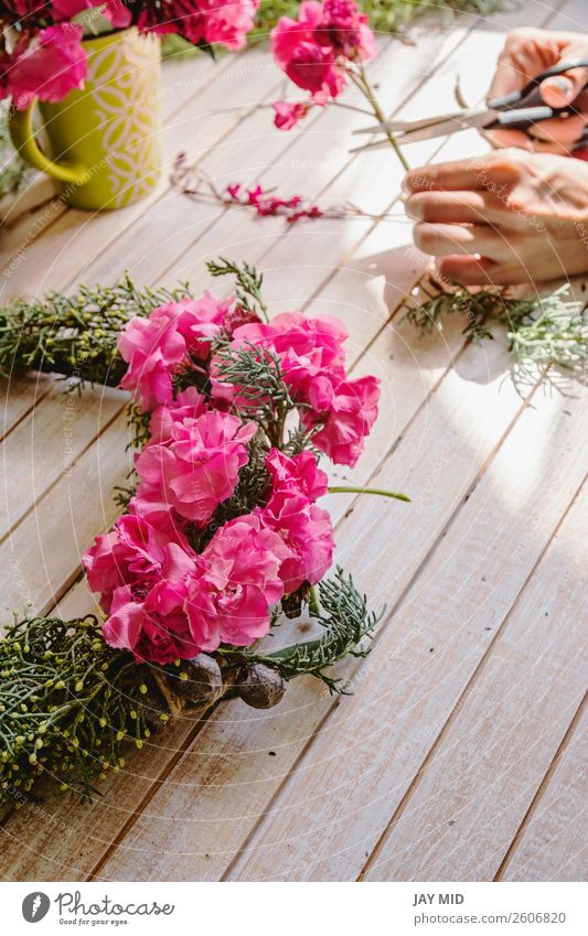 Florist bei der Arbeit: Erstellen eines Holzkranzes mit Zweigen aus Kiefernholz Dekoration & Verzierung Feste & Feiern Muttertag Erntedankfest