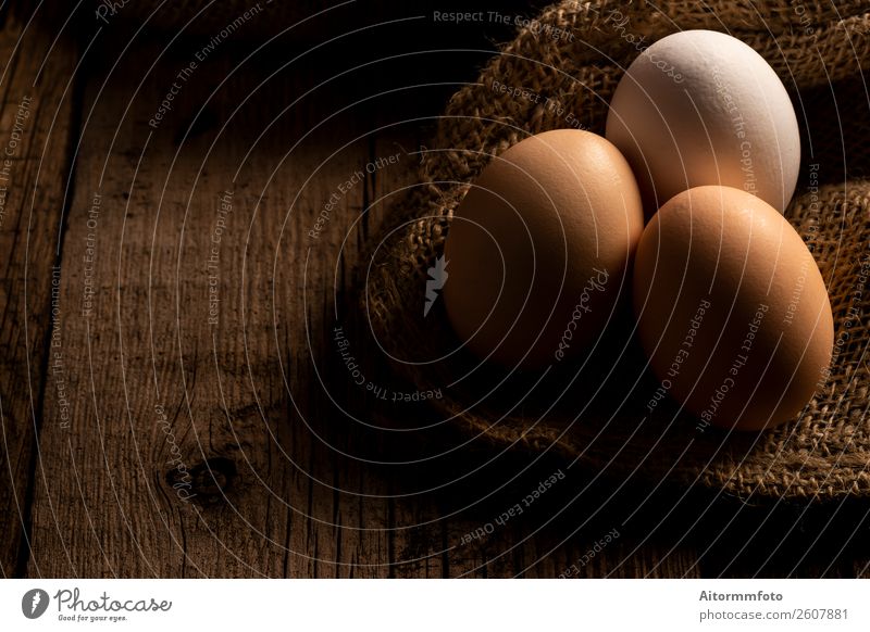 Frische Eier auf dunklem Holztisch Lebensmittel Ernährung Dekoration & Verzierung Tisch Ostern Natur Stoff frisch natürlich braun weiß Kreativität Tradition