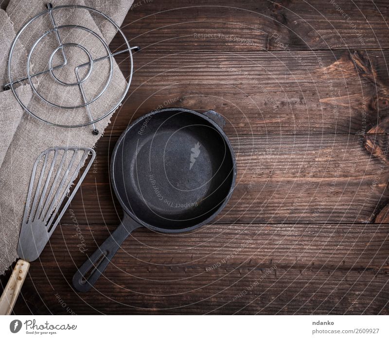 schwarze runde Gusspfanne aus Gusseisen Frühstück Abendessen Pfanne Besteck Küche Restaurant Werkzeug Metall Stahl stehen retro braun heimwärts leer