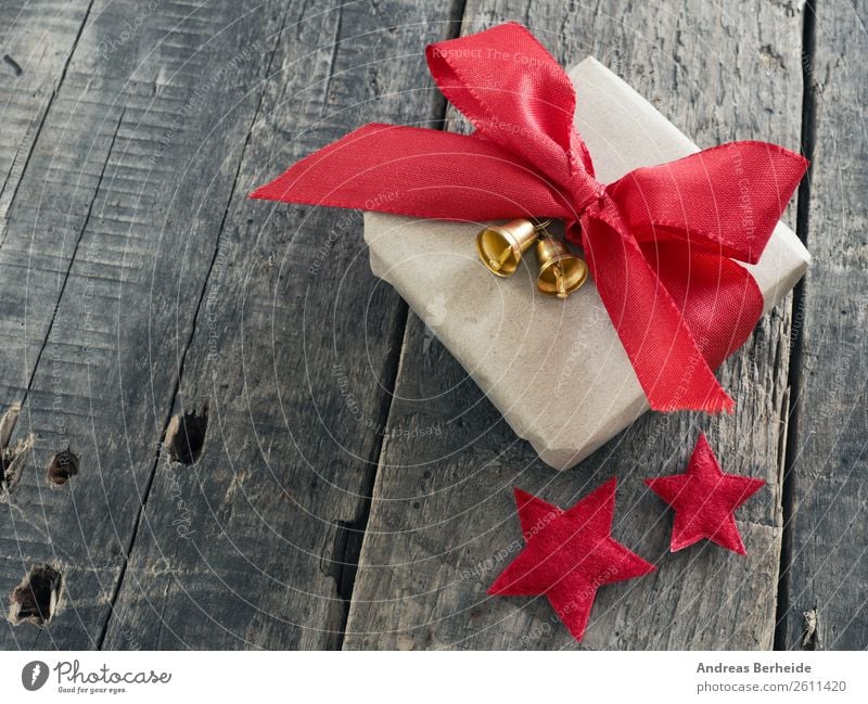 Ein Geschenk mit Schleifchen und Glöckchen Stil Winter Weihnachten & Advent Vorfreude Freude golden merry new nobody plank present red ribbon rustic season