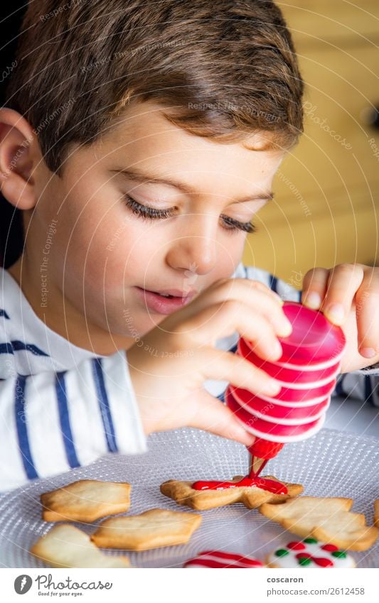 Kleines Kind schmückt Weihnachtsgebäck am Weihnachtstag Lebensmittel Teigwaren Backwaren Kuchen Dessert Lifestyle Freude Glück Freizeit & Hobby Kinderspiel