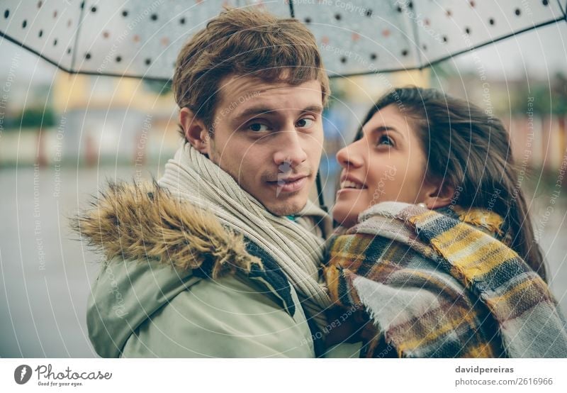 Ein glückliches Paar, das sich im Freien unter dem Regenschirm an regnerischen Tagen umarmt. Lifestyle Glück schön Winter Mensch Frau Erwachsene Mann