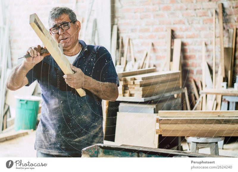 Älterer Zimmermann, der die Holzbohlen überprüft. Möbel Arbeit & Erwerbstätigkeit Handwerker Industrie Business Mann Erwachsene Großvater Vollbart alt machen