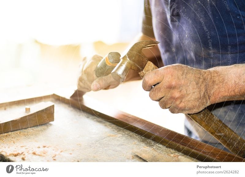 Der Schreiner arbeitet mit einem Meißel und einem Hammer. Freizeit & Hobby Möbel Arbeit & Erwerbstätigkeit Industrie Handwerk Werkzeug Mann Erwachsene Gebäude