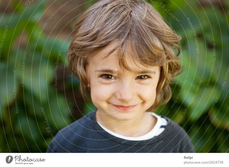 Entzückendes kleines Kind auf dem Feld mit Blick in die Kamera Freude Glück schön Gesicht Spielen Baby Junge Kindheit Natur Pflanze Baum Park Lächeln lachen