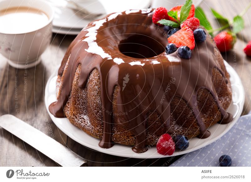 Schokoladen-Bundtorte mit Beeren Frucht Dessert Frühstück Kakao Kaffee Tee Geburtstag Blatt Holz frisch braun Kuchen Bundkuchen Glasur Erdbeeren Brombeeren