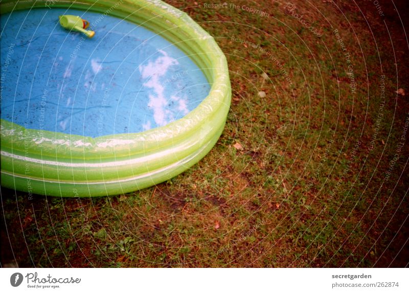 sonnenbaden. Gras Wiese Spielzeug Gießkanne rund blau braun grün Planschbecken Wasser nass Gummi kinderlos aufblasbar Kunststoff analog Farbfoto mehrfarbig