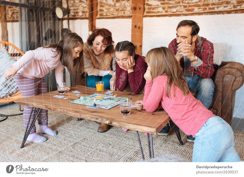 Glückliche Familie zu Hause auf der Couch mit klassischen Tischspielen Familie & Verwandtschaft Spielen Holzplatte Vater heimwärts Mensch Schwestern Kaukasier