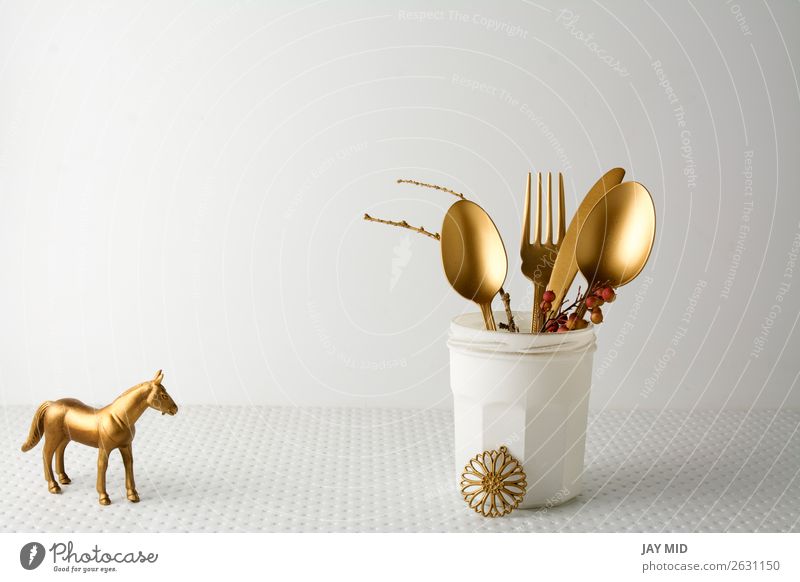 Festliches goldenes Besteckmesser und Gabellöffel in einer weißen Flasche. Mittagessen Abendessen Löffel elegant Design Dekoration & Verzierung Tisch Küche
