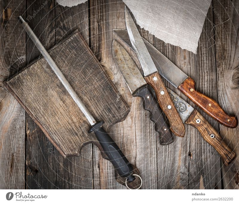 Holzschneidebrett und Messer mit Schärfung auf dem Tisch Küche Werkzeug Natur Metall Stahl Rost alt dreckig retro braun bügeln Hintergrund blanko Holzplatte