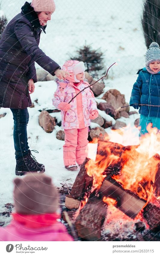 Die Familie, die Zeit zusammen verbringt, versammelt sich am Lagerfeuer. Lifestyle Freude Glück Freizeit & Hobby Winter Schnee Winterurlaub Garten Kind Mensch