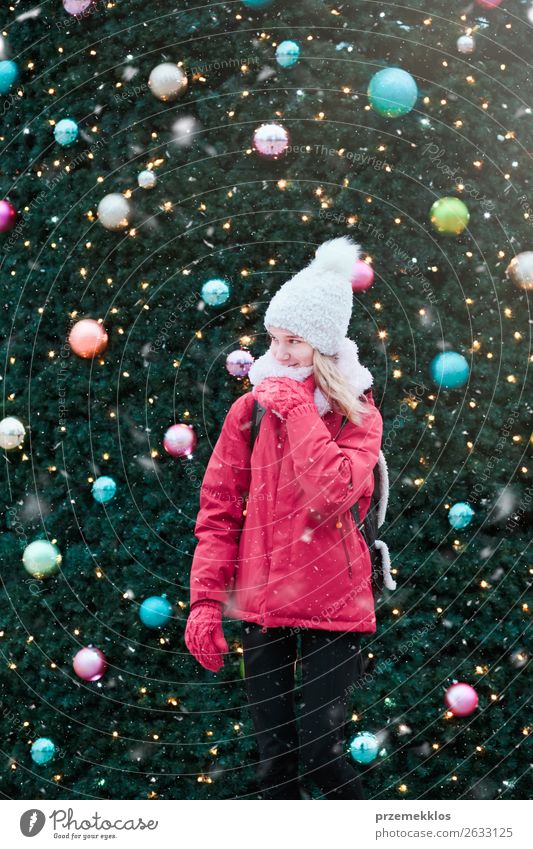 Junges Mädchen steht vor dem großen Weihnachtsbaum. Lifestyle Freude Winter Schnee Dekoration & Verzierung Weihnachten & Advent Mensch Junge Frau Jugendliche
