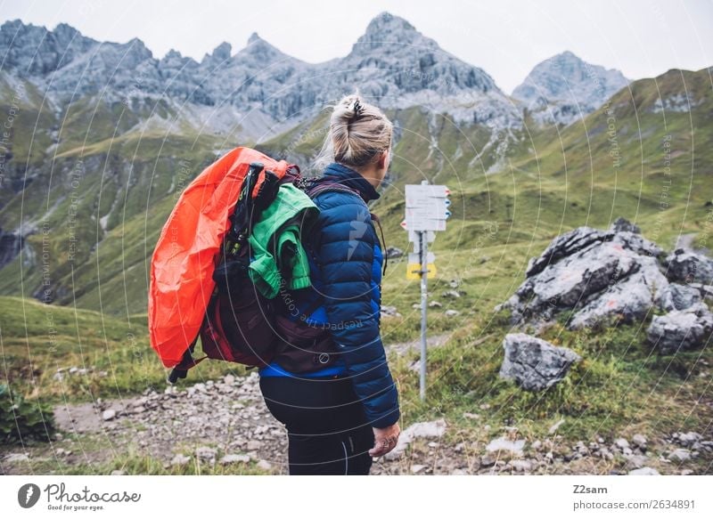 Junge Frau auf Alpenüberquerung Abenteuer wandern Jugendliche 18-30 Jahre Erwachsene Natur Landschaft Berge u. Gebirge daunenjacke Rucksack regenhülle blond