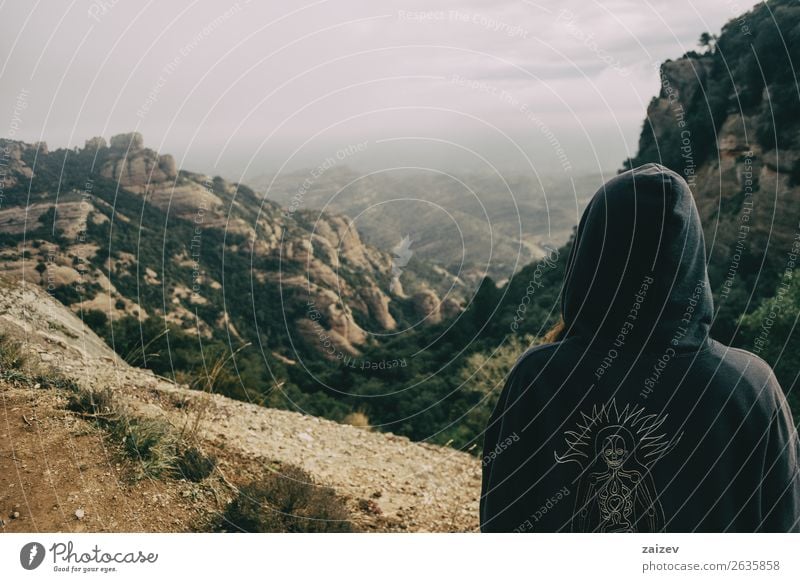 Mädchen auf dem Rücken mit Kapuze betrachtet eine Berglandschaft an einem Tag mit Wolken Lifestyle schön Erholung Ferien & Urlaub & Reisen Tourismus Ausflug