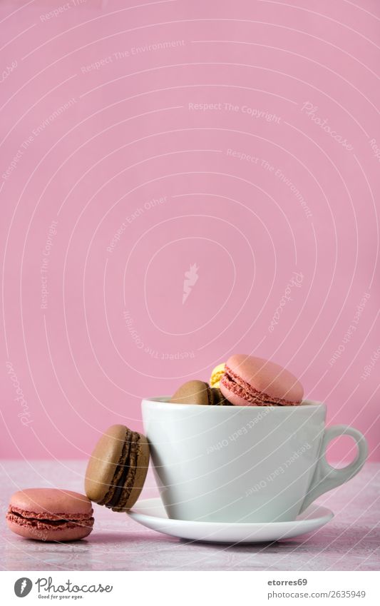 bunte Makronen aus einer Tasse auf rosa Hintergrund Macaron Erdbeeren Zitrone Dessert Kaffee gelb Schokolade Konfekt Himbeeren Tradition Süßwaren Biskuit