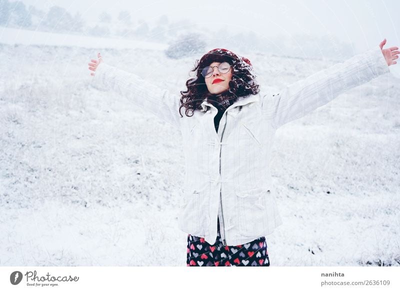 Junge und hübsche Frau, die einen verschneiten Wintertag genießt. Lifestyle Stil Glück Gesicht Wellness Leben Wohlgefühl Sinnesorgane Freizeit & Hobby Abenteuer