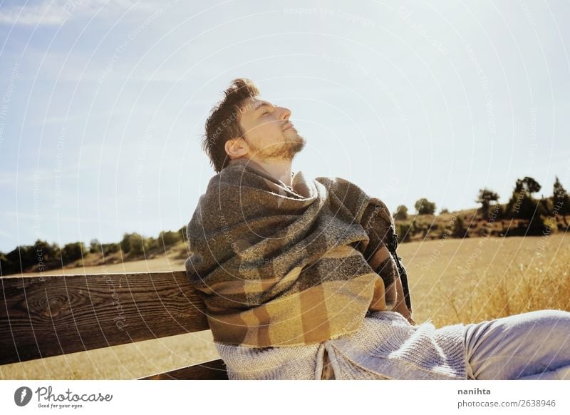 Seitenansicht eines jungen Mannes mit geschlossenen Augen Lifestyle Glück Gesicht Erholung ruhig Freiheit Sonnenbad Erwachsene Himmel Herbst Gras Schal Holz