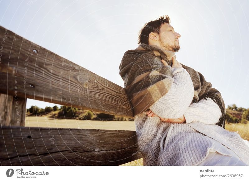 Seitenansicht eines jungen Mannes, der den ruhigen Morgen genießt. Lifestyle Glück Gesicht Erholung Freiheit Sonnenbad Erwachsene Himmel Herbst Schal Holz