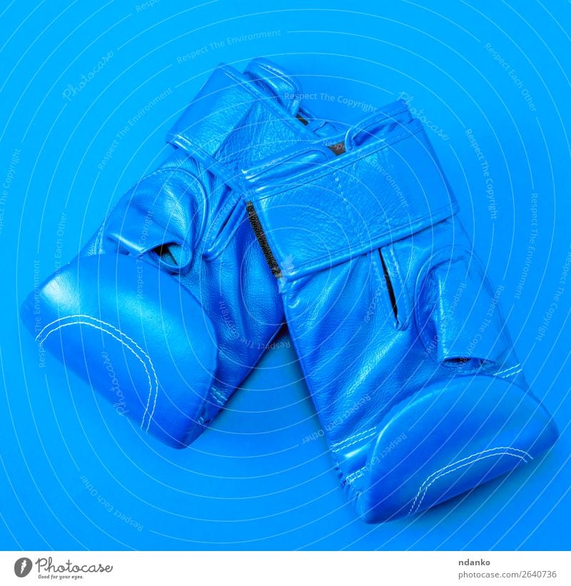 blaue Sportleder-Boxhandschuhe auf rotem Hintergrund Lifestyle Fitness Bekleidung Leder Handschuhe neu oben Schutz Farbe Konkurrenz Kreativität Kasten Boxer