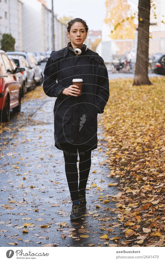 young woman walking along city street in autumn trinken Heißgetränk Kaffee Becher Lifestyle Stil Freizeit & Hobby Mensch feminin Junge Frau Jugendliche