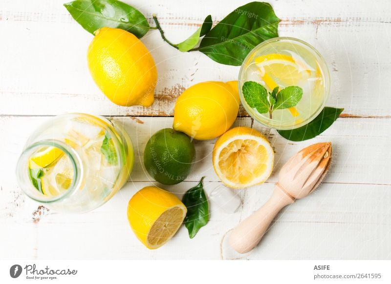 Hausgemachte Limonade mit Reibahle auf weißem Holztisch Frucht Diät Getränk Saft Sommer Tisch Blatt Coolness frisch oben gelb grün Zitrone Kalk Zitrusfrüchte