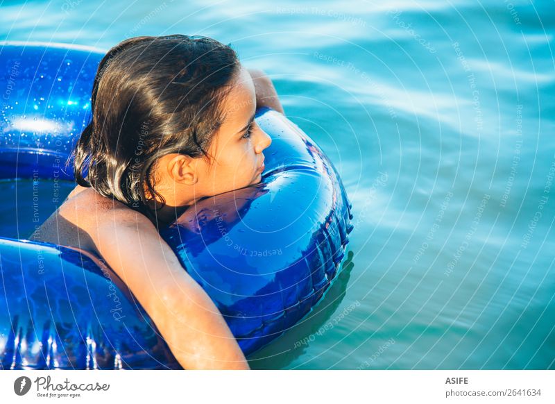 Glückliches kleines Mädchen, das mit einem Ring im Wasser schwebt. Lifestyle Freude schön Erholung Schwimmbad Freizeit & Hobby Spielen Ferien & Urlaub & Reisen