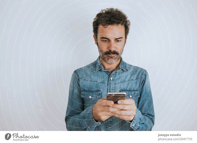 Porträtieren Sie einen Mann mit Schnurrbart mit seinem Smartphone. Lifestyle Gesicht Handy PDA Mensch Erwachsene Mode Hemd stehen Coolness trendy selbstbewußt