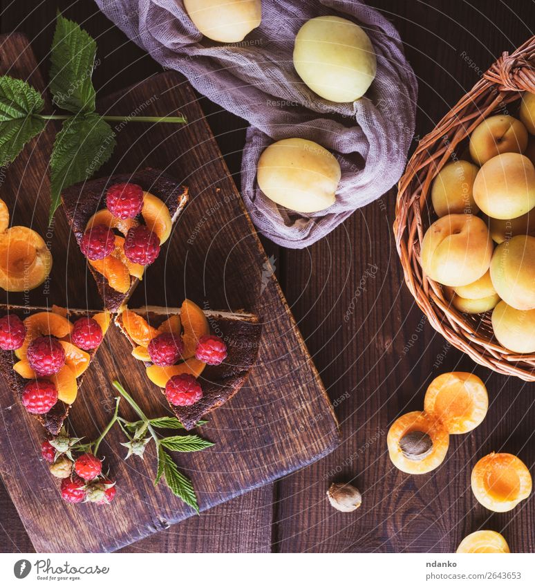 Käsekuchenstückchen mit Aprikose und Himbeere Milcherzeugnisse Frucht Dessert Ernährung Tisch Holz Essen frisch lecker braun rot weiß Farbe Snack Hintergrund