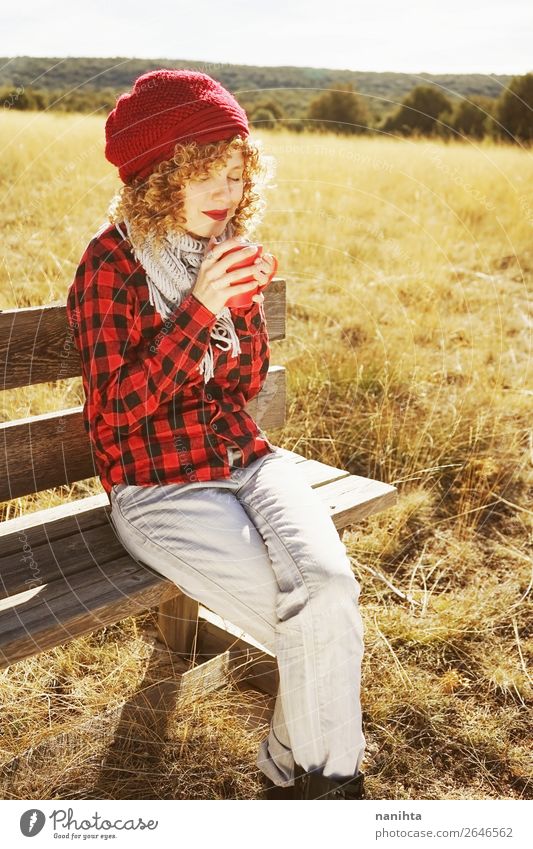 Eine junge Frau im rot karierten Hemd, die einen Becher nimmt. Frühstück Getränk Heißgetränk Kaffee Tee Lifestyle Wellness Leben Wohlgefühl Erholung ruhig