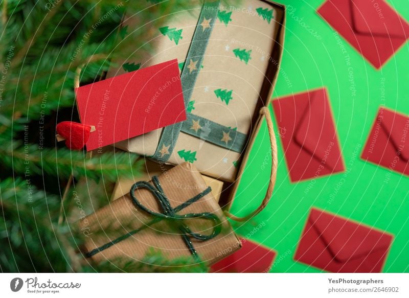 Papiertasche mit Geschenken unter dem Weihnachtsbaum und Papiernotiz. Feste & Feiern Weihnachten & Advent Fröhlichkeit grün rot Überraschung Tradition