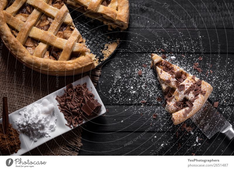 Traditionelle Apfelkuchen und Scheibe mit süßen Gewürzen. Kuchen Dessert Süßwaren Schokolade Teller Messer Tisch Küche schwarz Erntedankfest obere Ansicht