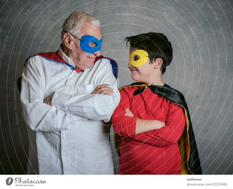 Grossvater mit Enkel als Superheld verkleidet auf grauem Hintergrund Lifestyle Freude Abenteuer Feste & Feiern Karneval Jahrmarkt Ruhestand maskulin Kind
