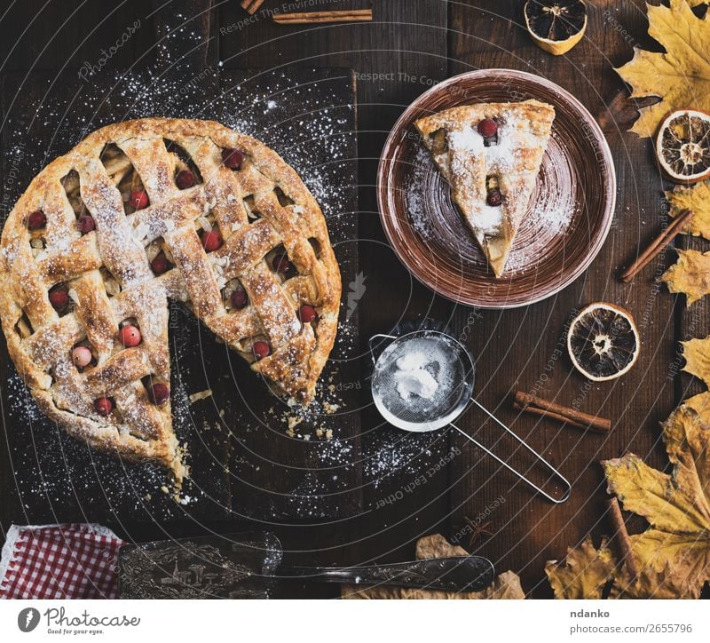 gebackener runder Apfelkuchen und ein geschnittenes Stück auf einem Teller Frucht Kuchen Dessert Mittagessen Abendessen Tisch Küche Herbst Holz Essen frisch