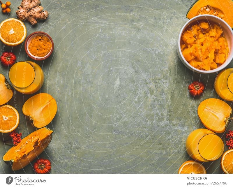 Orangefarbene Smoothie-Zutaten als Hintergrund für die kalte Jahreszeit mit Kürbis, Orangenfrüchten, Ingwer, Kurkuma und Kaki, Draufsicht, Rahmen, Kopierraum. Smoothie-Getränke für gesunde Stimmung und Energie