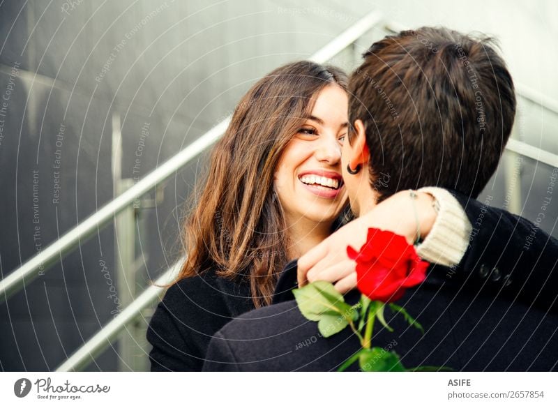 Ein glückliches Paar, das in eine Rose auf der Straße verliebt ist. Freude Glück schön Winter Feste & Feiern Valentinstag Frau Erwachsene Mann Hand Herbst Blume